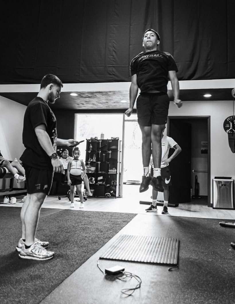 Kaiden timing an athlete's vertical jump on the jump mat